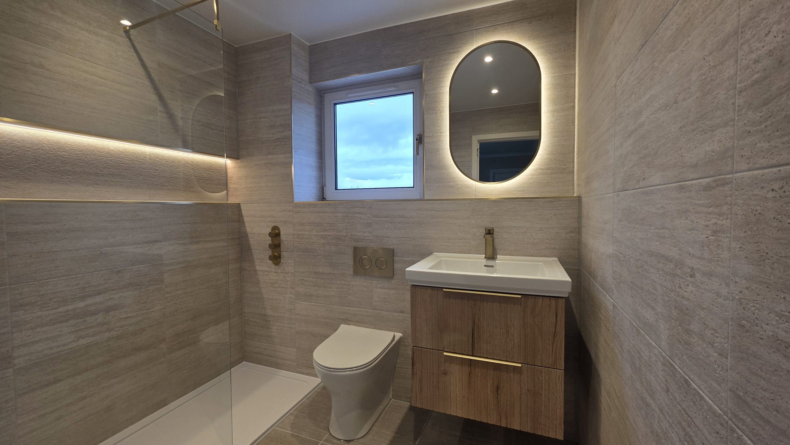 Bathroom in Bearsden with LED shelf, oval mirror and wood vanity by Clan Bathrooms
